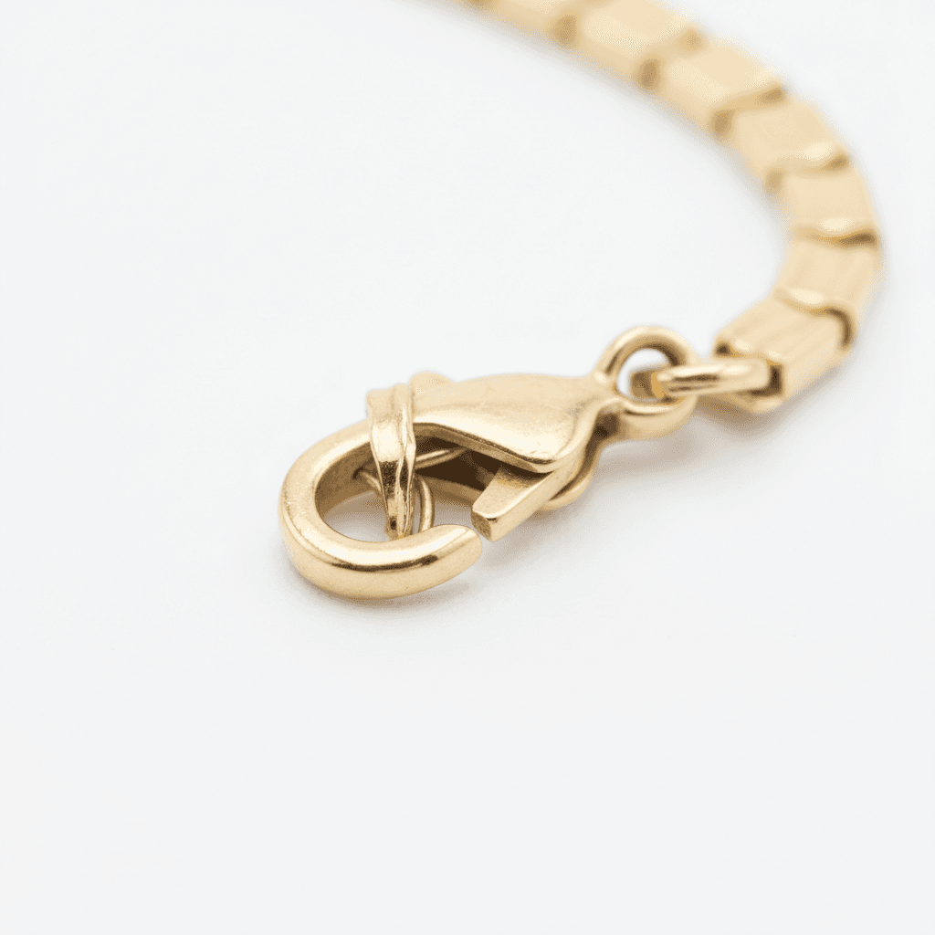 Close-up of a gold lobster clasp on a box chain bracelet