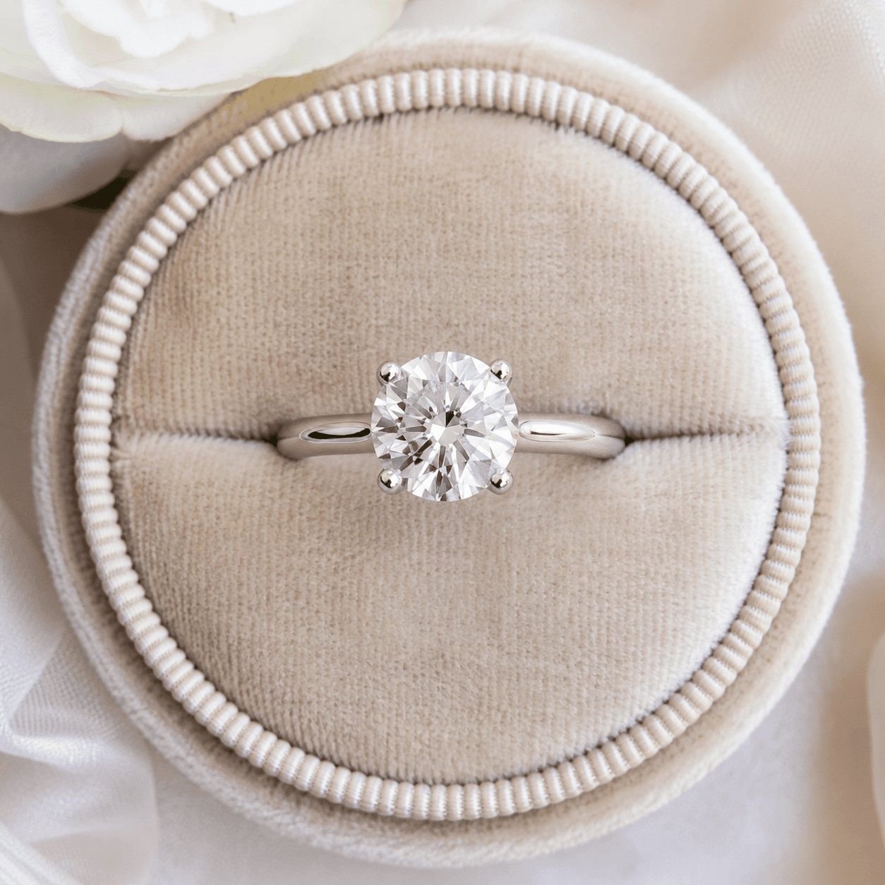 A finished platinum ring resting on a velvet ring cushion after repair, photographed from above, soft natural light