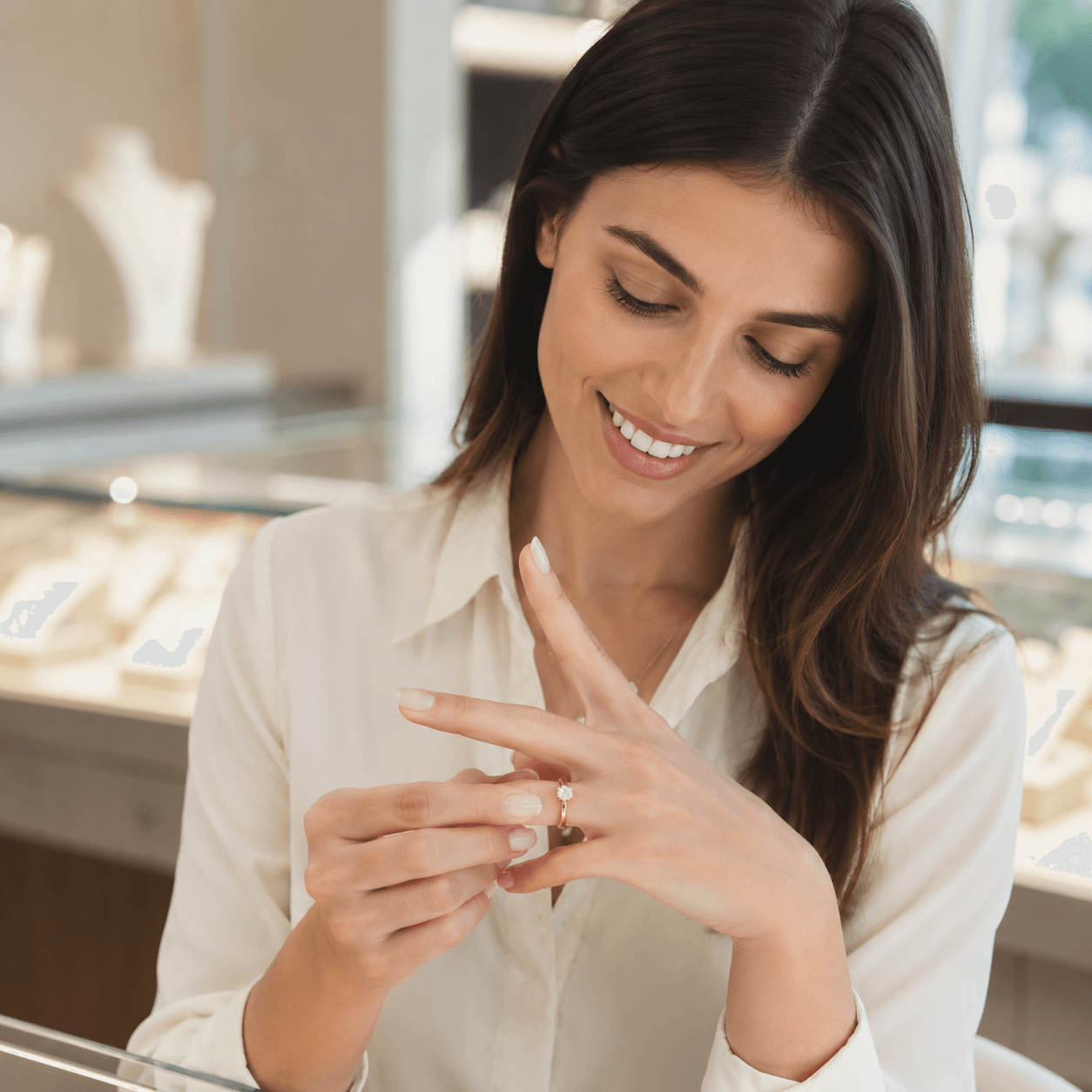 A smiling woman sliding a perfectly fitted ring onto her finger, shallow depth of field, soft natural window light in a