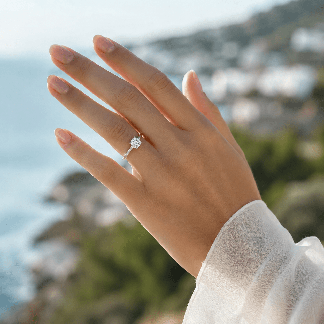 A woman's hand displaying a perfectly fitted diamond engagement ring, soft natural light, shallow depth of field with a