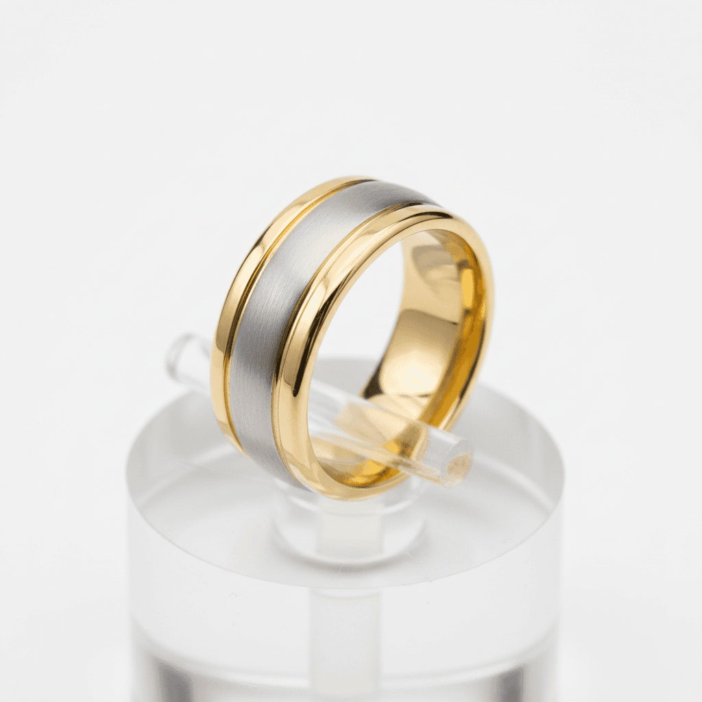 Wide two-tone wedding band with brushed silver centre and polished yellow gold edges on a clear display stand
